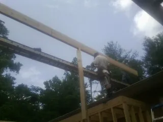 Carpenter setting a ridge beam over a new addition frame — Ice Dam Removal by Roofing Brothers in Rushville
