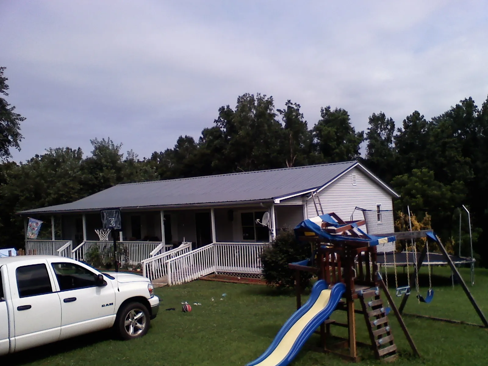 Dark metal roof on a country home with a full length front porch in Rushville